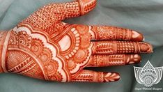 an orange and white henna on someones hand