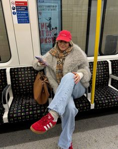 a woman sitting on a subway train reading a book