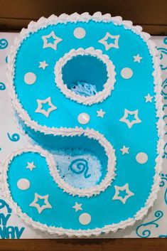 a blue and white birthday cake with the number six on it's bottom layer