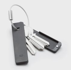 a bunch of keys that are connected to a keychain on a white surface