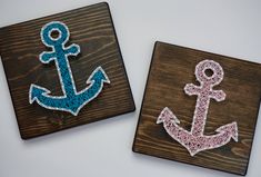 two wooden coasters with an anchor and letter on the front, one painted pink and blue