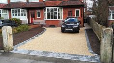 a black car parked in front of a red brick house