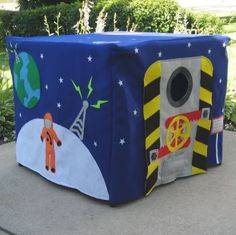 an outdoor space themed storage box on the side of a sidewalk with trees in the background