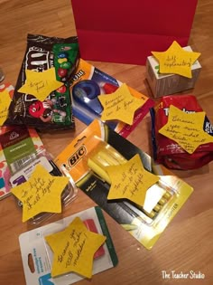 the table is covered with yellow sticky notes and star shaped candy bars, along with other school supplies