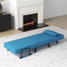 a blue chaise lounge sitting in front of a fire place on a white rug