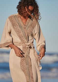 The Tranquility Kimono is a classic piece designed to embody Japanese style with tribal tones. Made of high quality 100% cotton that is both soft and sturdy, this piece is harmonies comfort and style.Hand-made with unique, earthy toned block prints on the front and sleeves and three-quarter length sleeves for easy movement.Can be worn open as a layer or closed as an elegant dress. Hand made with Love ❀ Luxury Cream Kimono For Spring, Luxury Beige Kimono For Spring, Luxury Women's Kimono For Daywear, Luxury Bohemian Kurta For Beach, Luxury Bohemian Kurta For The Beach, Luxury Bohemian Unstitched Traditional Wear, Luxury Bohemian Traditional Wear For Summer, Luxury Bohemian Tunic With Kimono Sleeves, Luxury Kimono With Tie Waist For Daywear