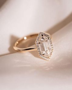 an engagement ring with a large diamond in the center on top of a white cloth