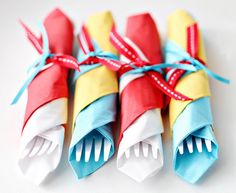 four colorful toothbrushes tied together with blue and red ribbons on white background, top view