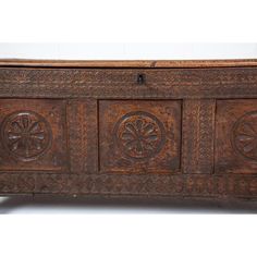 an old wooden chest with carvings on the front and sides, sitting against a white background