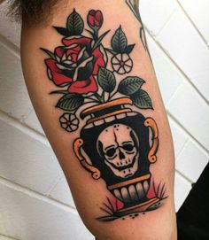 a skull and roses tattoo on the arm