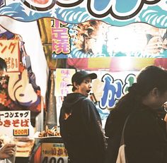 people are standing in front of a food stand