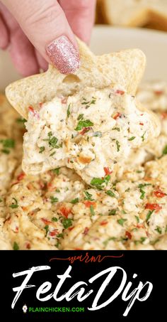 a hand dipping a tortilla chip into a bowl full of feta dip