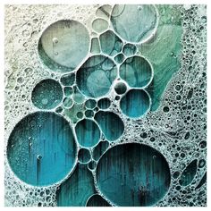 an abstract painting with blue and green circles on the bottom, surrounded by water droplets