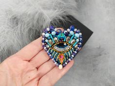 "Beautiful heart eye brooch is lovely handmade by me. 💓 This beautiful hand embroidered evil eye brooch took hours of precision and elaborate embroidery work. SIZE ~ 1,97\" x 1,97\" ( 5 cm x 5 cm) MATERIALS Made of czech seed beads and japanese seed beads, glass crystal, glass beads. Back side made of eco leather. Beaded jewelry requires careful and loving care. Avoid contact with hairspray, perfume, water, bleaches & lotions. Avoid over exposure to humidity, heat & sun. Gently wipe you Bohemian Brooch Pins For Gifts, Bohemian Handmade Pins As Gift, Handmade Bohemian Brooch For Gifts, Handmade Bohemian Brooch As Gift, Handmade Bohemian Brooches As Gifts, Bohemian Handmade Brooches As Gifts, Evil Heart, Leather Beaded Jewelry, Evil Eye Jewellery