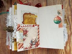 an open christmas card book on top of a wooden table next to other cards and decorations