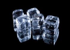 ice cubes are stacked on top of each other in front of a black background