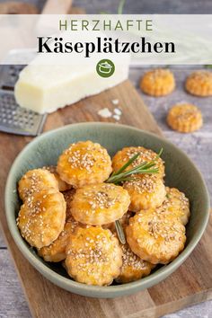 a green bowl filled with baked goods on top of a wooden cutting board next to cheese