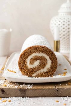 a cinnamon roll on a plate with powdered sugar