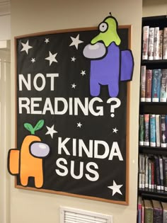 a sign that reads not reading kinda sus in front of bookshelves