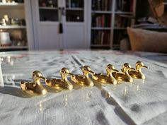 four brass ducks sitting on top of a table