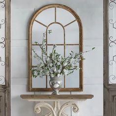 a vase filled with flowers sitting on top of a white table next to a window