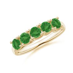 a gold ring with green stones on the sides and four stone in the middle, all set together