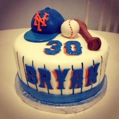 a birthday cake decorated with baseball, bat and hat on top of a white table