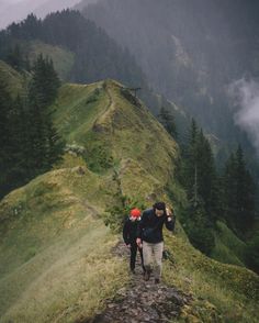 two people walking up the side of a mountain