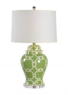 a green and white lamp with a white shade on the top, sitting against a white background