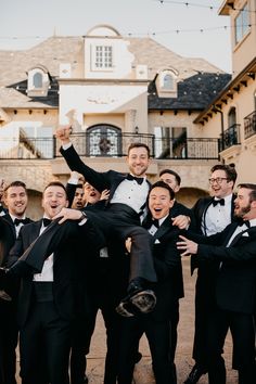 a group of men in tuxedos are posing for a photo with each other