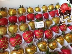 chocolate covered strawberries and strawberries with gold foiled strawberry decorations on display for sale