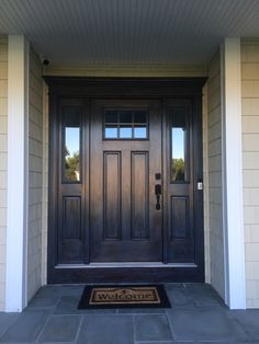 a front door with a welcome mat on it