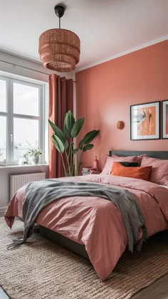 a bedroom with orange walls and pink bedding in the corner, along with a large window