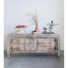 an old wooden table with some plants on top