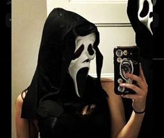 a woman wearing a mask taking a selfie with her cell phone