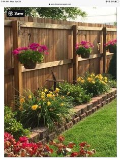 a wooden fence with flower pots on it and flowers growing in the planter boxes