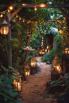 an outdoor path with lanterns and lights in the middle of it, surrounded by greenery