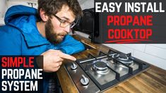 a man is pointing at the propane cooktop