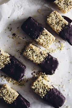 chocolate covered desserts sitting on top of white parchment paper with sprinkles