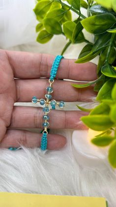 Handcrafted in light blue, this macrame bracelet combines a simple, minimalist design with a hypoallergenic gold cross and faceted crystals. It is ideal for manifesting Catholic or Christian spirituality, perfect for everyday wear or as a gift for a loved one on holidays such as Christmas or an anniversary. It comes presented in a gift-ready box.  * * * * * * * * * DETAILS * * * * * * * * * *  This listing is for one bracelet:  This bracelet is made with high quality thread.  It is adjustable to fit almost all wrist sizes. It has a 2.5 inch extension.  The beads are glass crystals.  My bracelets are symbols of love, friendship, and appreciation. They are perfect gifts for yourself or to show someone how much you care. So, I invite you to explore my store and find that bracelet that touches Adjustable Blue Rosary Bracelet With Cross, Adjustable Blue Cross-shaped Jewelry, Christian Spirituality, Jewelry Spiritual, Blue Macrame, Spiritual Bracelets, Catholic Jewelry, Macrame Bracelet, Bracelets Handmade Beaded