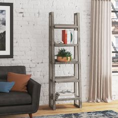 a living room with a couch, chair and book shelf in front of a brick wall