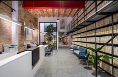 the interior of an office with rows of shelves and blue chairs in front of them