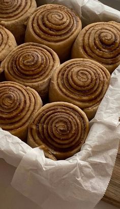 several cinnamon rolls in a basket on top of a table