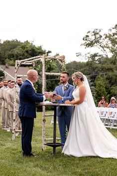 a bride and groom exchanging vows at their outdoor ceremony