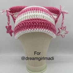 a pink and white crocheted hat on top of a mannequin head