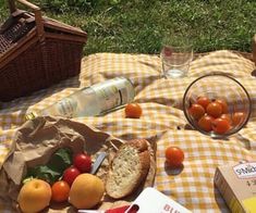 a picnic table with bread, tomatoes, and other food items on top of it