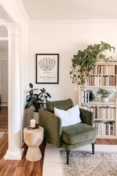 a living room filled with furniture and bookshelves next to a wooden floor covered in plants