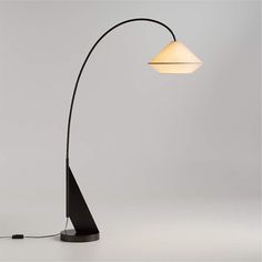 a black lamp with a white shade on it's head and an iron base