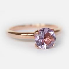 a ring with a pink stone on the side and a rose cut diamond in the middle