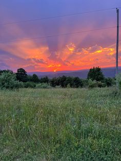 the sun is setting over an empty field